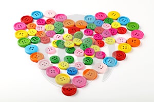 Heart shaped of colorful sewing buttons on white