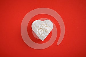 Heart shaped cooked rice on red background.