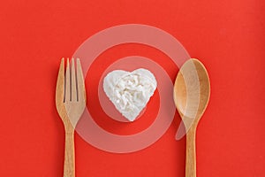 Heart shaped cooked rice in wooden plate on red background.