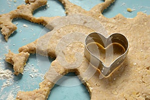 Heart-shaped cookie cutter on raw dough Cyan tabletop