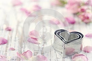 Heart shaped cookie cutters on wooden background