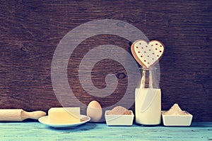 Heart-shaped cookie and the ingredients for cook it, with a filt photo