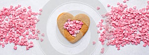 Heart shaped cookie and pink candy hearts for Valentines Day.