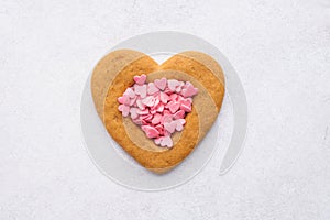 Heart shaped cookie and pink candy hearts for Valentines Day.