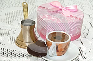 Heart shaped cookie with red gift box with bow and cup of coffee