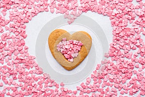 Heart shaped cookie surrounded with pink candy hearts.