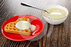 Heart shaped cookies poured condensed milk in saucer, spoon in bowl with condensed milk on wooden table