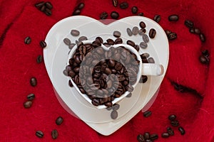 Heart shaped cup with coffee beans on red