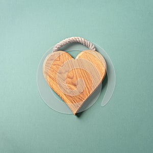 Heart shaped cutting board over blue and green background. Top view. Copy space. Valentines day concept