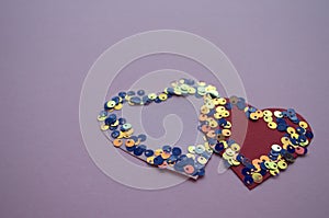 Heart shaped frame made of shiny sequins on a blue background. Festive texture for Valentines Day, Mothers Day, Womens