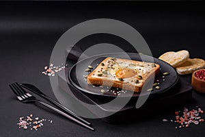 Heart shaped fried egg in bread toast with sesame seeds, flax seeds and pumpkin seeds on a black plate