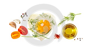 Heart shaped fried egg seasoned with green onions and dill; olive oil bowl and sliced cherry tomatoes isolated on white