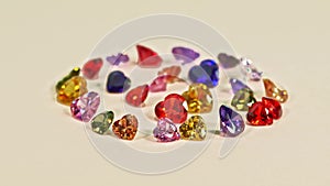 Heart-shaped gemstones in various colors are set in a circle.