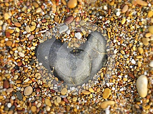 Heart-shaped granite rock on a pebble beach