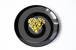 Heart-shaped green polka dots on a black saucer with a white background