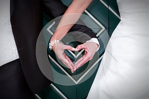 Heart shaped hands of bride and groom on wedding