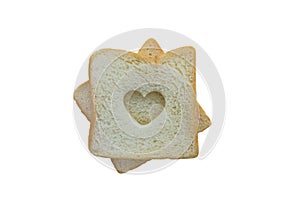 Heart shaped hole in a slice of bread isolated