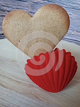 heart-shaped homemade gingerbread placed in a red jewelry box on a light wooden background. Valentine's Day, greeting