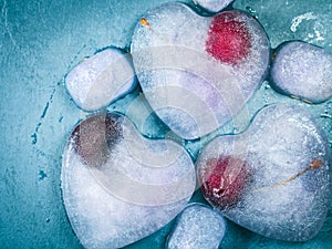 Heart shaped ice cubes with frozen cherry