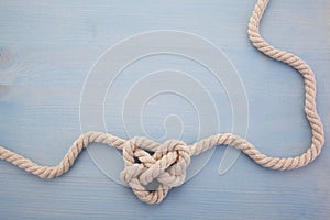 Heart shaped knot on blue wooden background