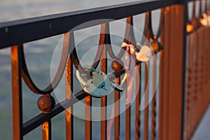 Heart-shaped locks hang on the fence on the river embankment as a sign of love and loyalty for a wedding