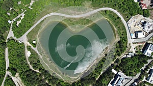 Heart shaped love lake shot. Aerial drone view of peace symbol in natural environment. Overhead natural wonder pond