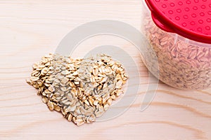 Heart-shaped oatmeal on wooden background