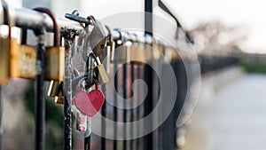 Heart-shaped padlock locked on the fence photo