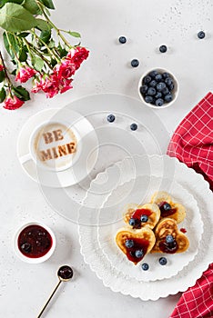 Heart shaped pancakes and a cup of coffee on a white background. Festive breakfast for Valentine`s Day, sweet valentine. Poster,