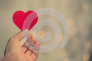 Heart-shaped paper hand handle on bokeh background., Valentine`s Day beautiful background