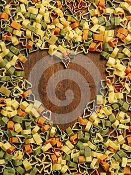 Heart-shaped pasta on wood background