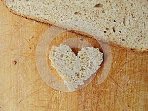 Heart shaped piece of bread in front of full bread