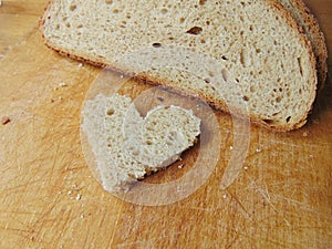 Heart shaped piece of bread in front of full bread