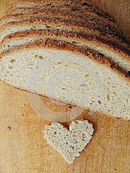 Heart shaped piece of bread in front of full bread