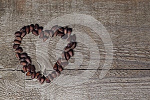 Heart shaped pine nuts on wooden background