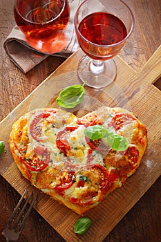 Heart shaped pizza with red wine