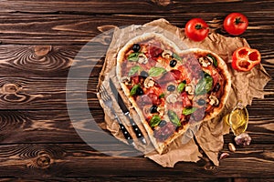 Herz geformt ein großes rundes blatt hellen teigs tomaten a Valentinstag auf der uralt hölzern. mahlzeit aus 