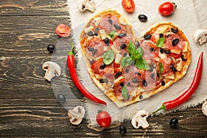 Heart-shaped pizza, Valentine`s Day. With vegetables. A concept of tasty and healthy food with love. Free-lay