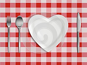 Heart shaped plate, fork, spoon and knife top view