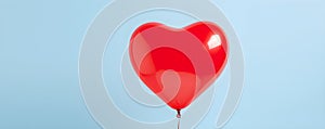 Heart shaped red air balloon flying in blue sky. Symbol of love. St Valentine's day concept