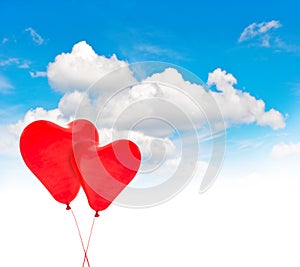 Heart shaped red balloons in blue sky. Valentines Day background