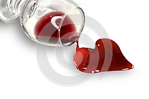 Heart shaped red wine pouring from glass. The concept of love, disappointment, heartache, heart disease