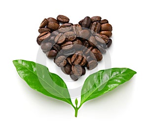 Heart shaped roasted coffee beans and leaves, fair trade concept image