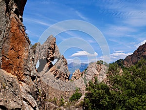 Heart-shaped rock hole at the red cliffs of the Calanche de Piana, UNESCO world heritage. Corsica, France.