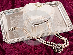 Heart-shaped satin box with pearls on silver tray