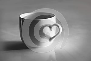 Heart shaped shadow on a coffee cup, black and white