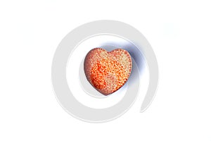 Heart shaped small orange balls on a white background. Round bath salt. Isolate