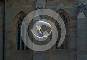 Heart-shaped soap bubble explodes in front of a church