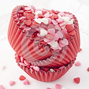 Heart shaped sprinkles in baking cups. photo