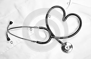 A heart shaped stethoscope. Close up. On a white coat